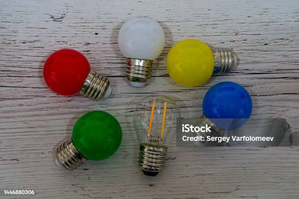 Lamps Of Different Colors For Christmas Garland Beltlight On Pale Wood Board Stock Photo - Download Image Now