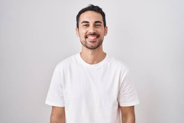 istock Handsome hispanic man standing over white background with a happy and cool smile on face. lucky person. 1446884165