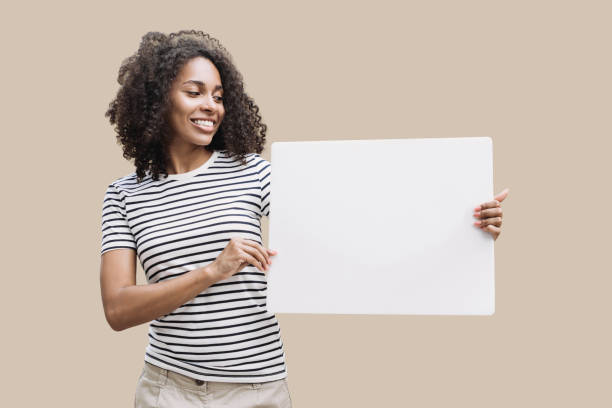 Happy young woman holding blank white banner isolated stock photo