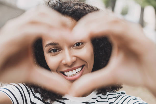 istock Smiling woman making a heart shape with hands closeup 1446884376