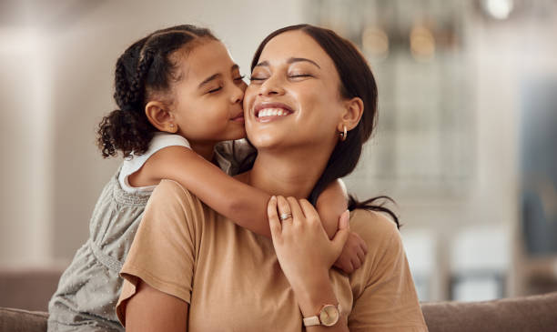 happy, kiss and hug on mothers day in living room sofa, love and relaxing together in australia family home. young girl, smile parent and happiness, quality time and care on lounge couch for fun - 母親節 個照片及圖片檔