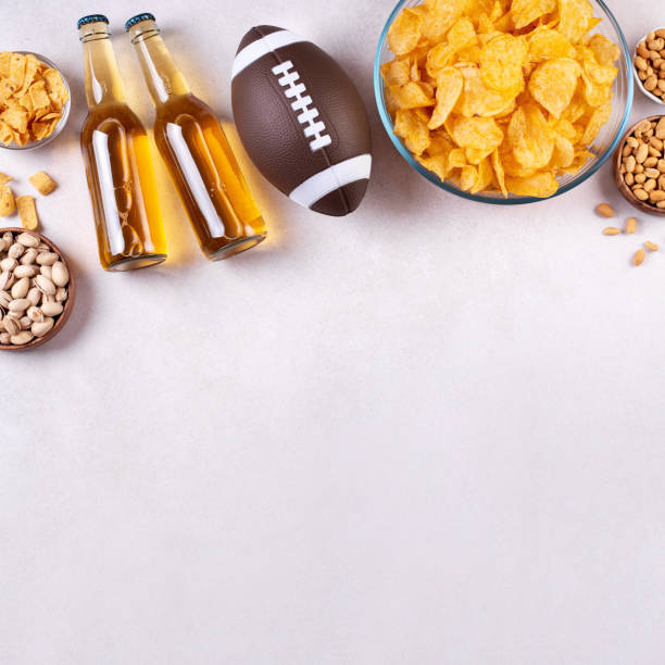 병에 담긴 맥주와 럭비 공이 있는 콘크리트 테이블에 간식, 게임 밤 음식 - american football football food snack 뉴스 사진 이미지