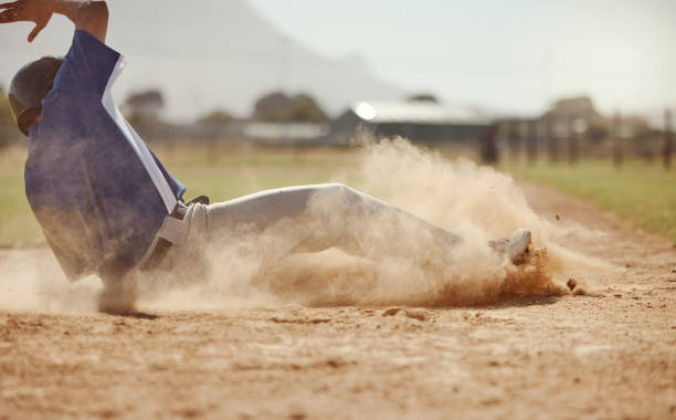 baseball, baseball player running and diving for home plate in dirt during sport ball game competition on sand of baseball pitch. sports man, ground slide and summer fitness training at dallas texas - base runner imagens e fotografias de stock