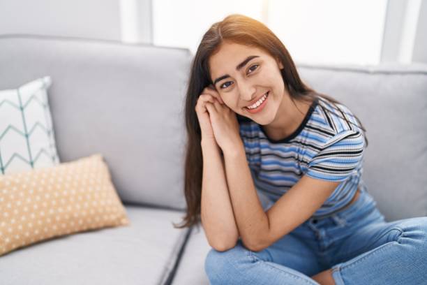 istock Young hispanic girl smiling confident sitting on sofa at home 1446885982