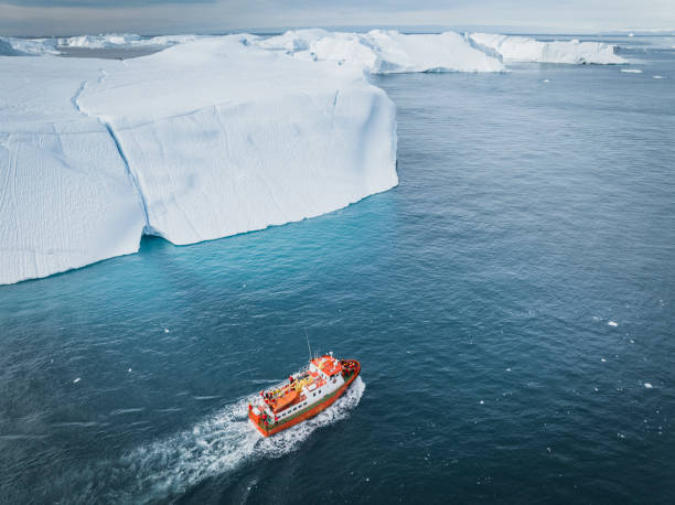 istock small boat sailing between big icebergs 1446886290