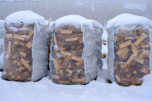 Three large bags for storing and transporting dry firewood. Cold winter, actual. Energy crisis.