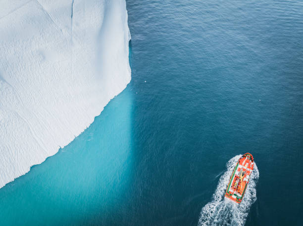 istock small boat sailing between big icebergs 1446886314