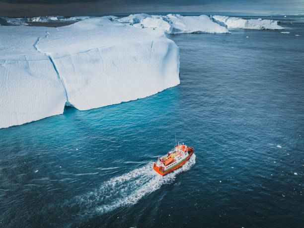 istock small boat sailing between big icebergs 1446886315