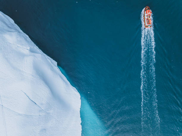 istock small boat sailing between big icebergs 1446886316