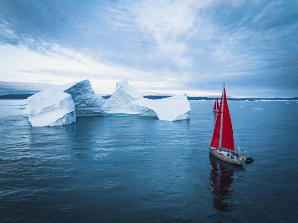 istock sailboat with red sails sailing among large icebergs 1446886329