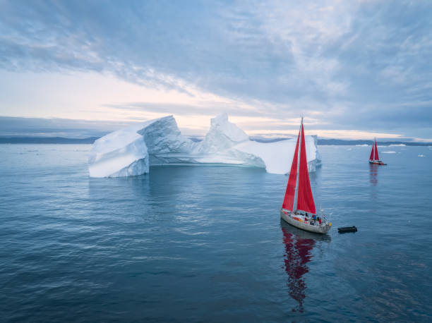 istock sailboat with red sails sailing among large icebergs 1446886332