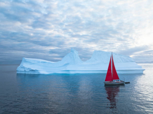 istock sailboat with red sails sailing among large icebergs 1446886366