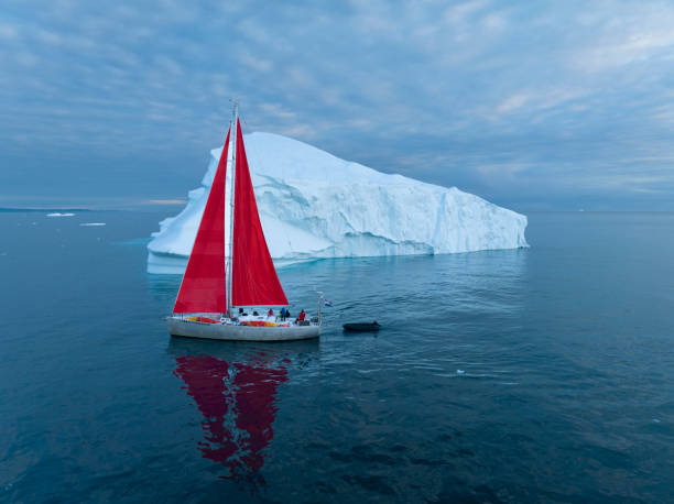 istock sailboat with red sails sailing among large icebergs 1446886367