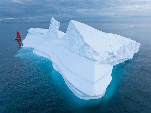 istock sailboat with red sails sailing among large icebergs 1446886387