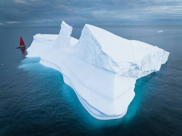 istock sailboat with red sails sailing among large icebergs 1446886393