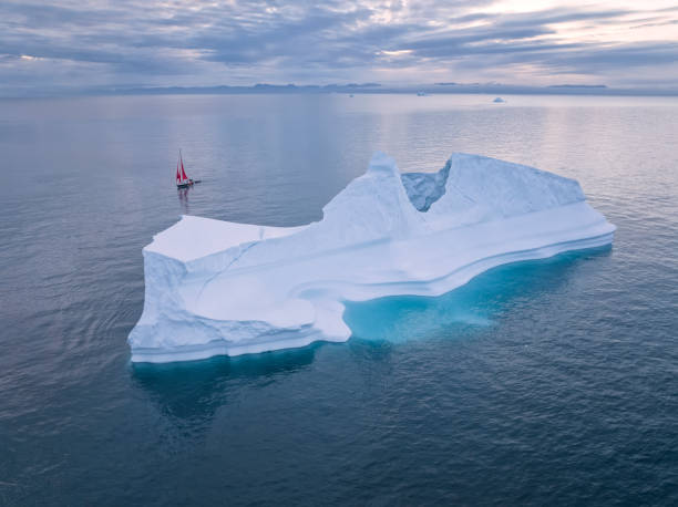 istock sailboat with red sails sailing among large icebergs 1446886412