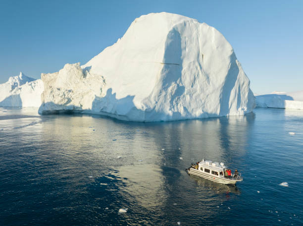 istock small boat sailing between big icebergs 1446886456