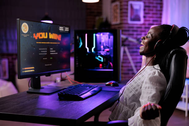 istock Female player celebrating successful video games online win 1446887737
