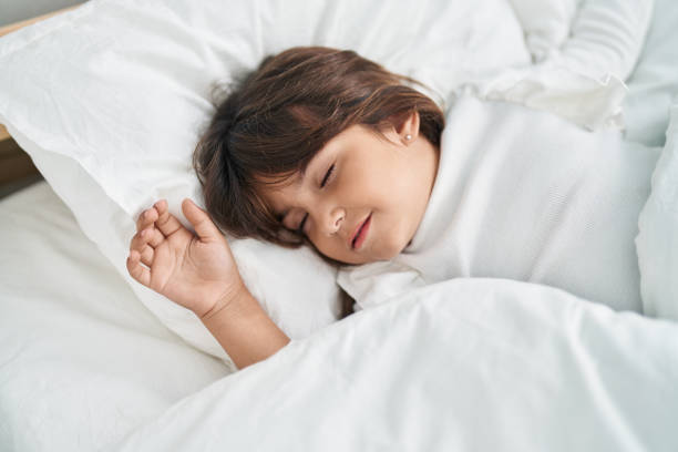 istock Adorable hispanic girl lying on bed sleeping at bedroom 1446887809