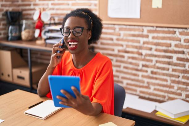 istock African american woman business worker talking on smartphone using touchpad at office 1446888000