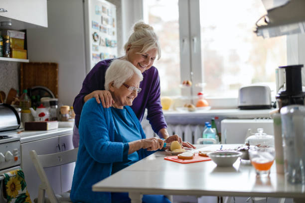 donna che trascorre del tempo con la sua madre anziana a casa - grandmother senior adult family domestic kitchen foto e immagini stock