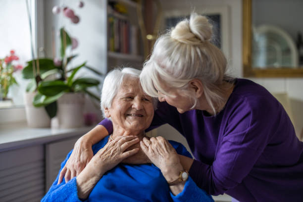 mujer abrazando a su anciana madre - alzheimer fotografías e imágenes de stock