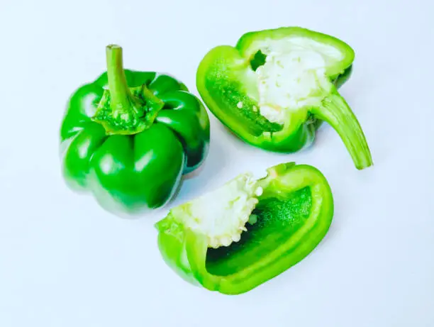 Capsicum sweet bell pepper vegetable food ingredient shimla mirch bellpeppers whole and halved cut half sliced closeup image stock photo