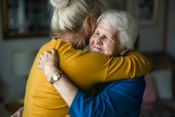 donna che abbraccia la sua madre anziana - grandmother senior adult smiling women foto e immagini stock