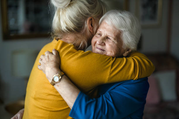 mulher que abraça sua mãe idosa - grandmother senior adult smiling women - fotografias e filmes do acervo