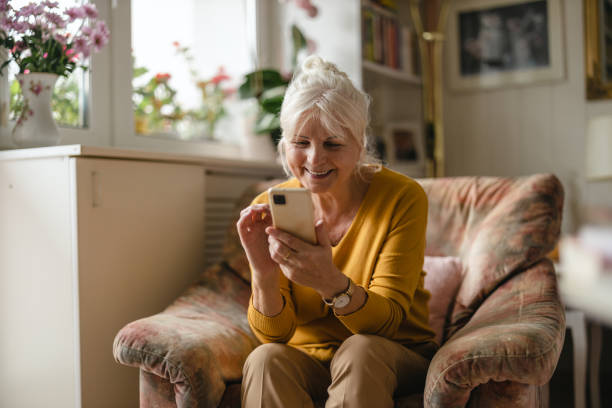 istock Senior woman using mobile phone at home 1446888510