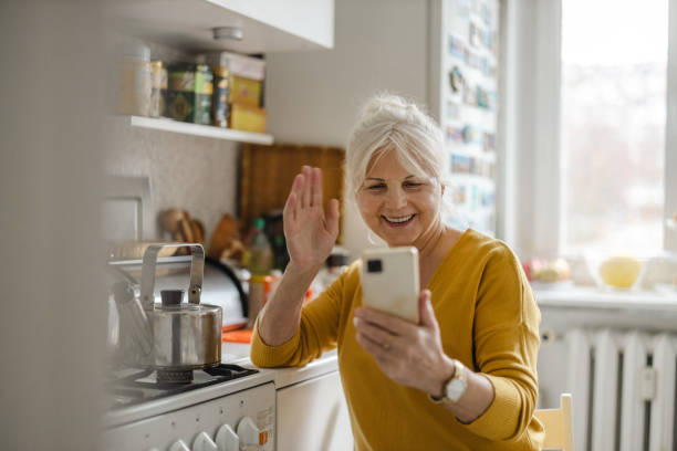 istock Senior woman using mobile phone at home 1446888550