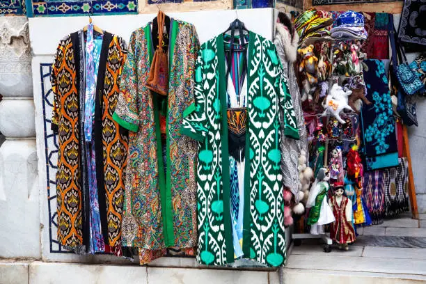 Uzbek traditional clothes such as robes and other colorful souvenirs, Tashkent, Uzbekistan.
