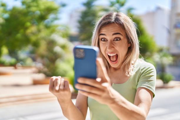 istock Young woman using smartphone with cheerful expression at park 1446889492