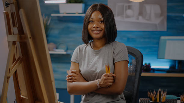 istock Smiling black artist sitting in art studio space with craft tools 1446891310