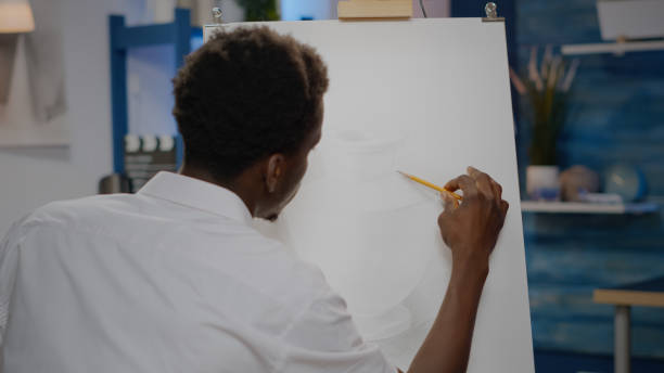 istock Young black artist using art pencil on canvas for vase drawing 1446891661