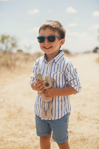 Happy boy holding a toy rabbit. Hare.