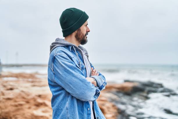 istock Young bald man standing with arms crossed gesture at seaside 1446894131