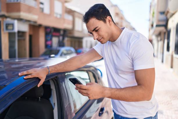 istock Young hispanic man using smartphone leaning on car at street 1446894246