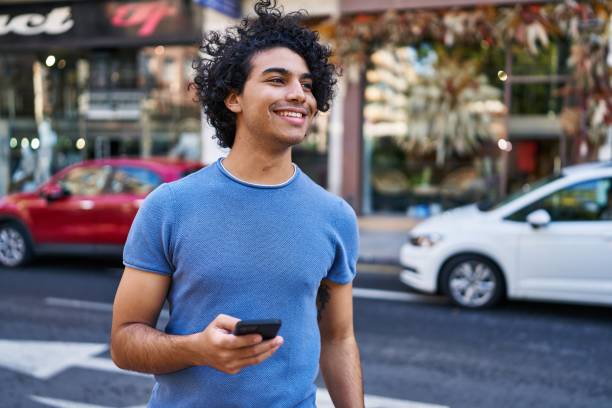 istock Young hispanic man smiling confident using smartphone at street 1446895514