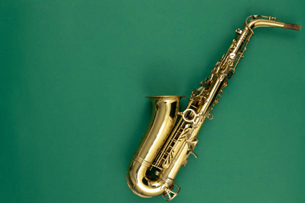 saxofone em um fundo verde, vista superior. - isolated brass key macro - fotografias e filmes do acervo
