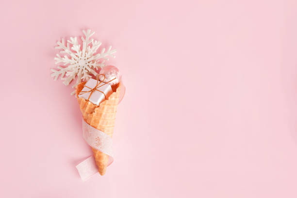 istock Ice Cream Cone with Christmas Decoration gift box, snowflake on pink pastel background. Minimal Christmas Concept. Flat Lay 1446897569