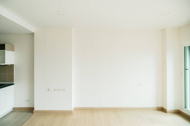Empty room is decorated with an engineering wooden floor with baseboard and wallpaper on the wall with sunlight from the window. Minimalist interior design and real estate for decoration. Real image.