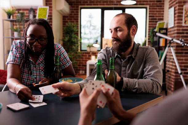 istock Diverse group of people sitting at home while playing charades card game together. 1446897797