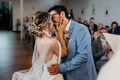 bride and groom kissing at the wedding ceremony in the church