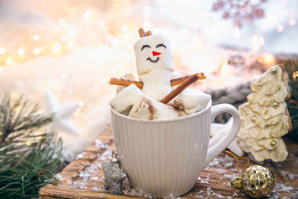 Christmas background with marshmallow snowman in a cup.