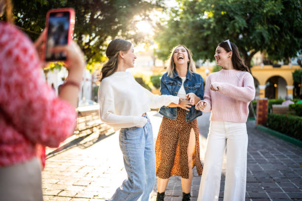 młodzi przyjaciele filmujący za pomocą telefonu komórkowego na świeżym powietrzu - mobile phone group of people photographing teenager zdjęcia i obrazy z banku zdjęć