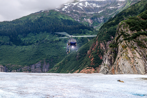A helicopter gets ready to touch down on the Mendenhall Glacier located just outside of Juneau, Alaska.