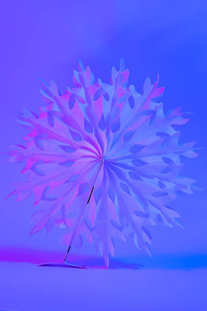 istock Neon Christmas winter background with paper snowflake close up. 1446899153