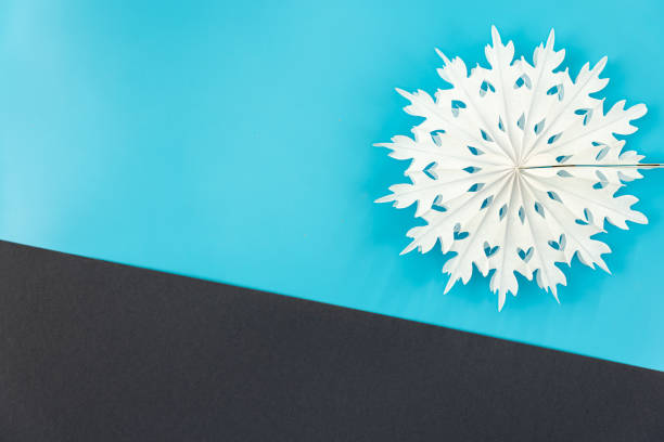 Volumetric paper snowflake on a colored background, flat lay, copy space.