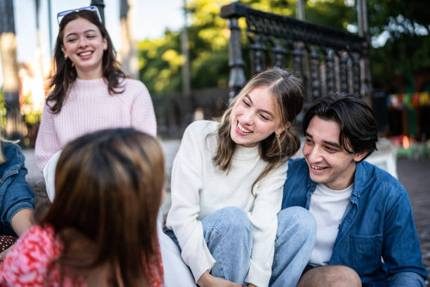 istock Young friends sitting and talking outdoors 1446900026